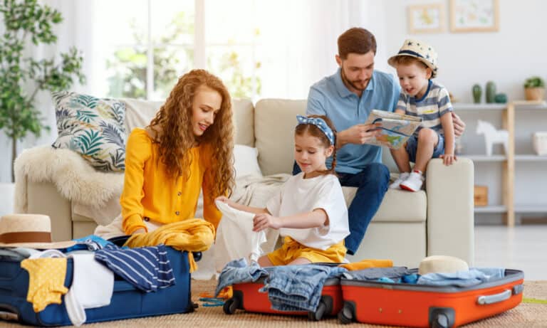 Family preparing for vacation while packing on floor at home